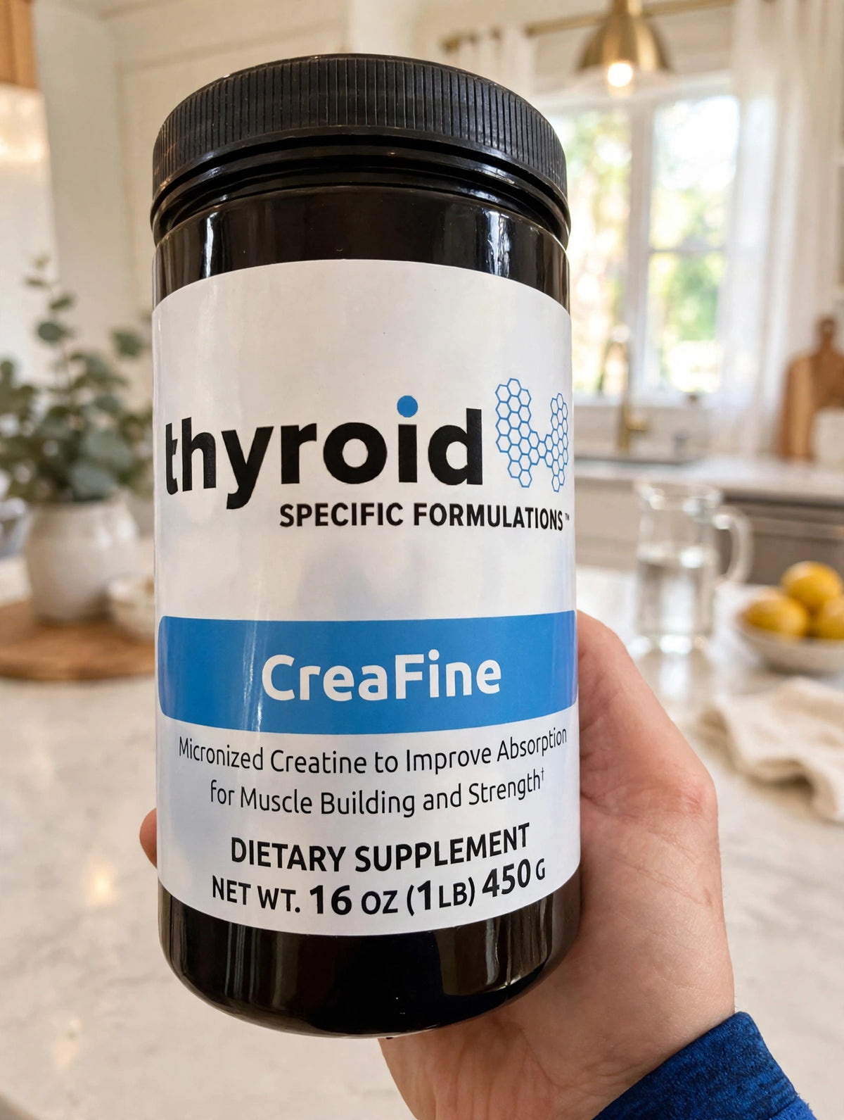 Hand holding a jar of CreaFine in a kitchen